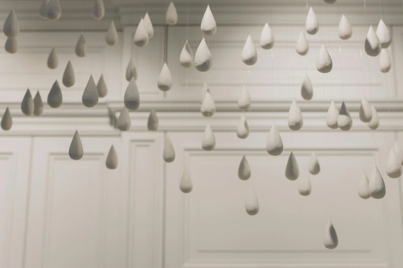 a room filled with lots of raindrops hanging from the ceiling, a marble sculpture, inspired by Cornelia Parker, unsplash, silver，ivory, tear drop, hammershøi, animation