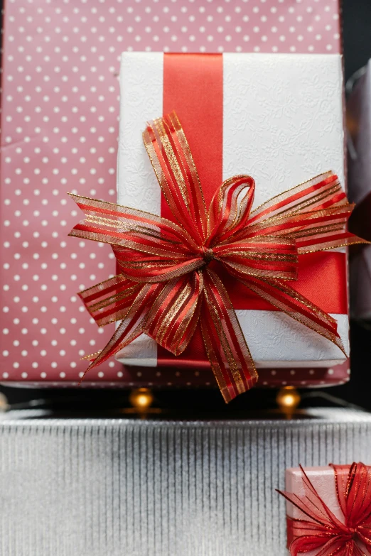 a pile of presents sitting on top of each other, red ribbon, up-close, lit from above, wine