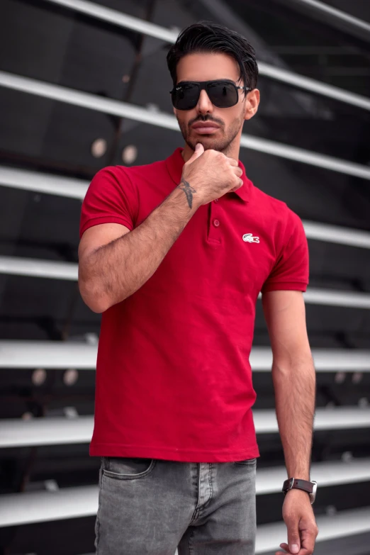 a man standing in front of a row of bleachers, inspired by Luis Molinari, pexels contest winner, wearing polo shirt, red car, wearing oakley sunglasses, real trending on instagram image