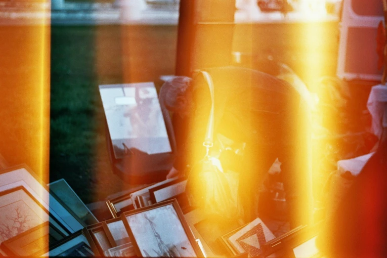 a man sitting in a chair in front of a window, a polaroid photo, unsplash, happening, flares anamorphic, stacked computer screens, sunny amber morning light, scratches and burns on film