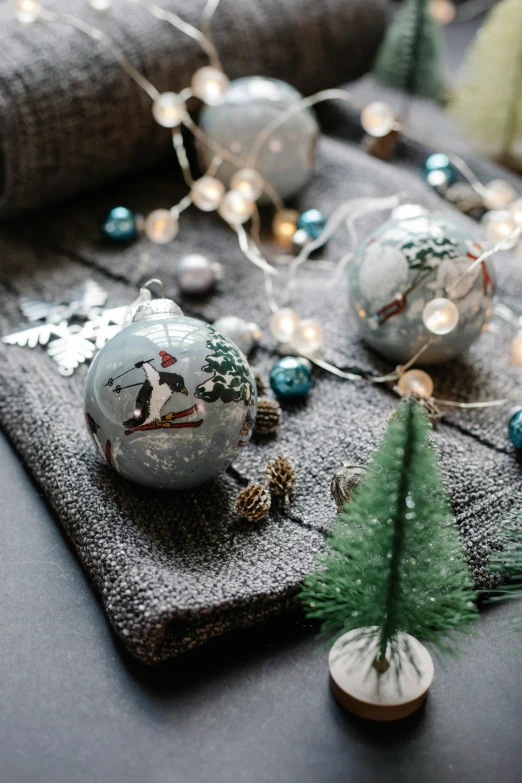 a bunch of ornaments sitting on top of a table, inspired by Ernest William Christmas, winter scene, on grey background, warmly lit, thumbnail