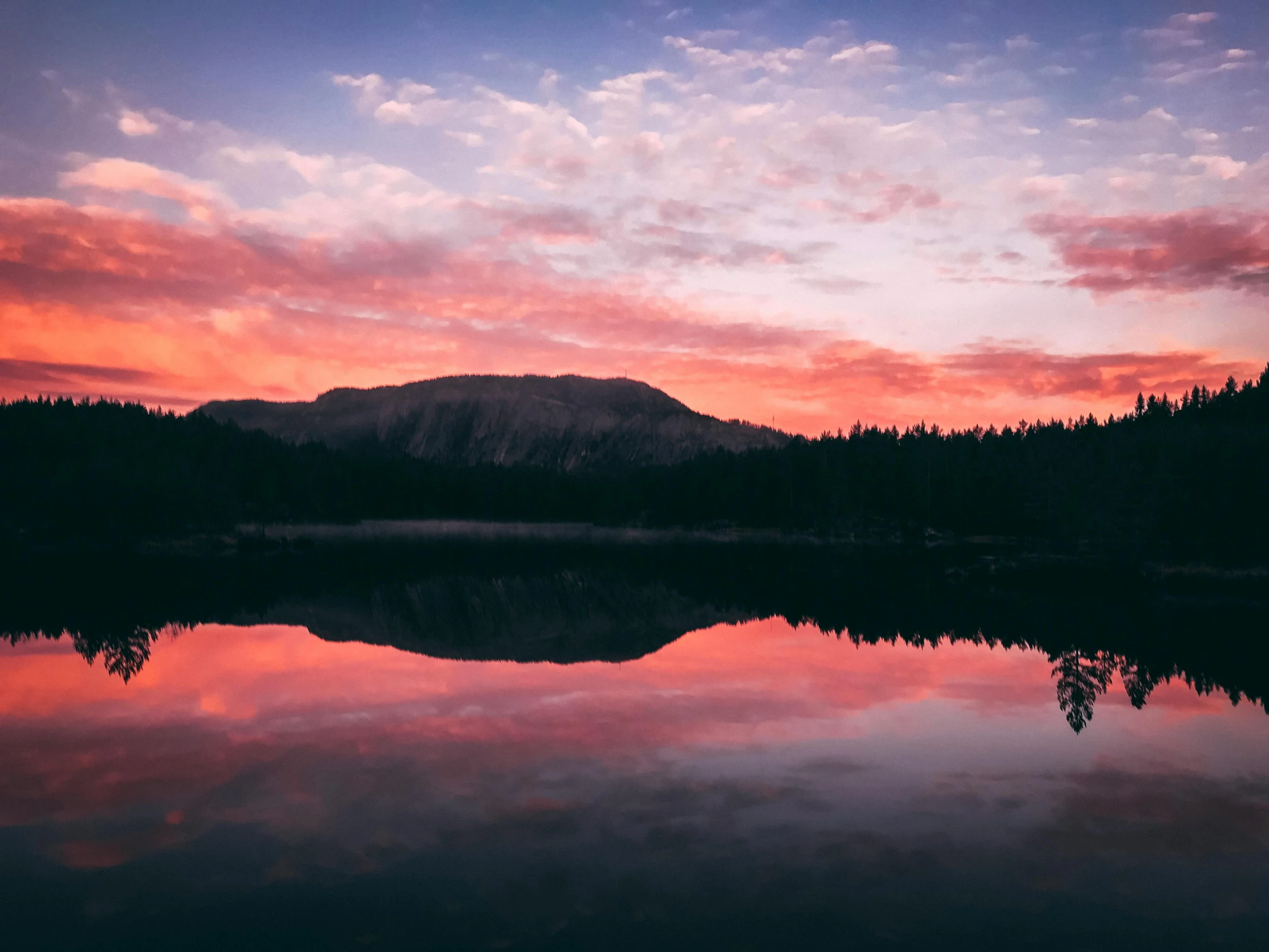 a large body of water with a mountain in the background, unsplash contest winner, romanticism, orange / pink sky, mirror lake, minna sundberg, end of the day