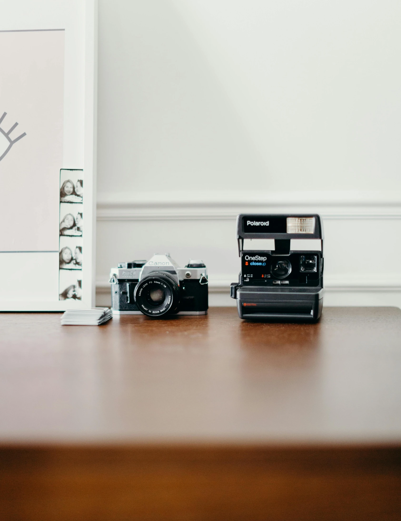 a couple of cameras sitting on top of a wooden table, a polaroid photo, unsplash contest winner, minimalist photo, toy camera, bright daylight indoor photo, historical photo