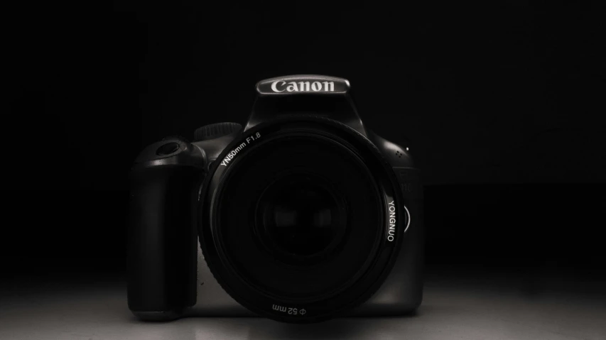 a canon camera sitting on top of a table, inspired by Yousuf Karsh, pexels contest winner, canon eos 1000d, front lit, candid!! dark background, canon 24mm