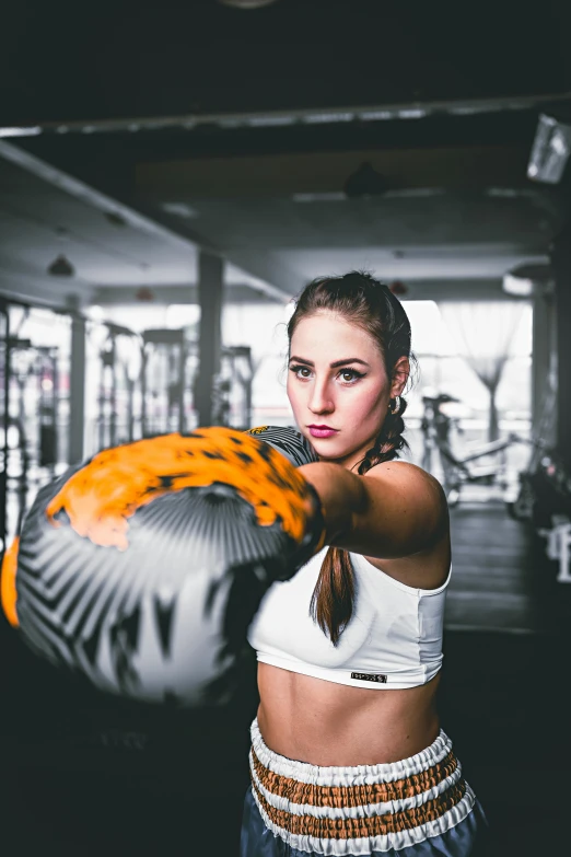 a woman with boxing gloves in a gym, by Adam Marczyński, pexels contest winner, holding a ball, avatar image, pixelated, sports bra