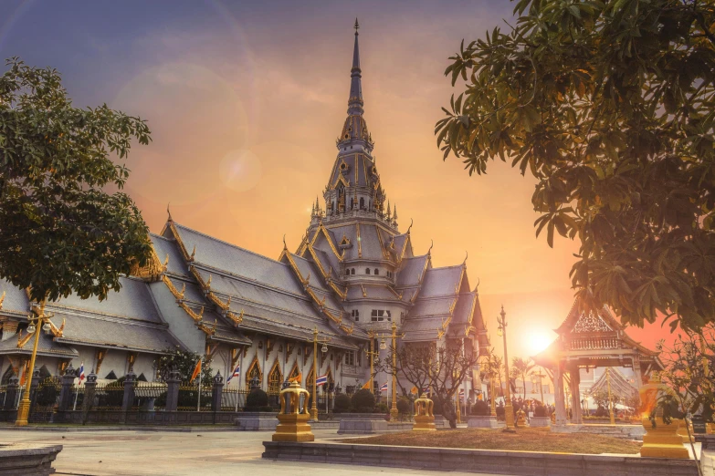 a large building in the middle of a park, pexels contest winner, thai temple, sun rising, asymmetrical spires, gold