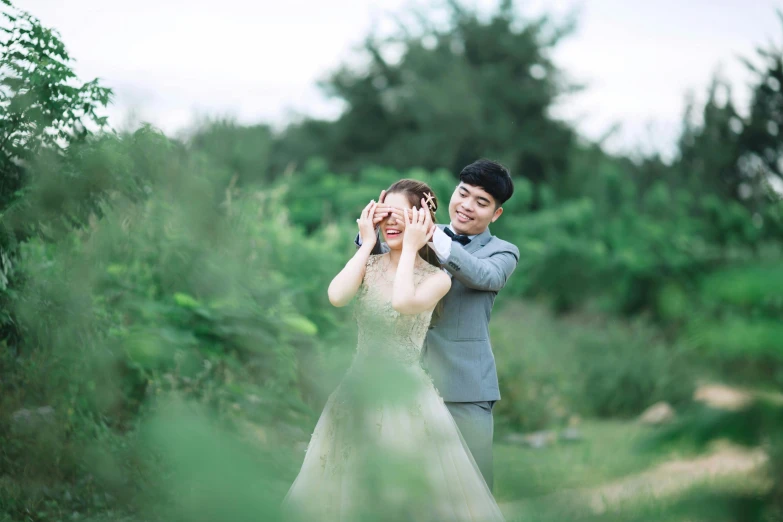 a man and a woman standing next to each other, a picture, by Tan Ting-pho, unsplash, romanticism, greeting hand on head, greenery, laughing groom, youtube thumbnail