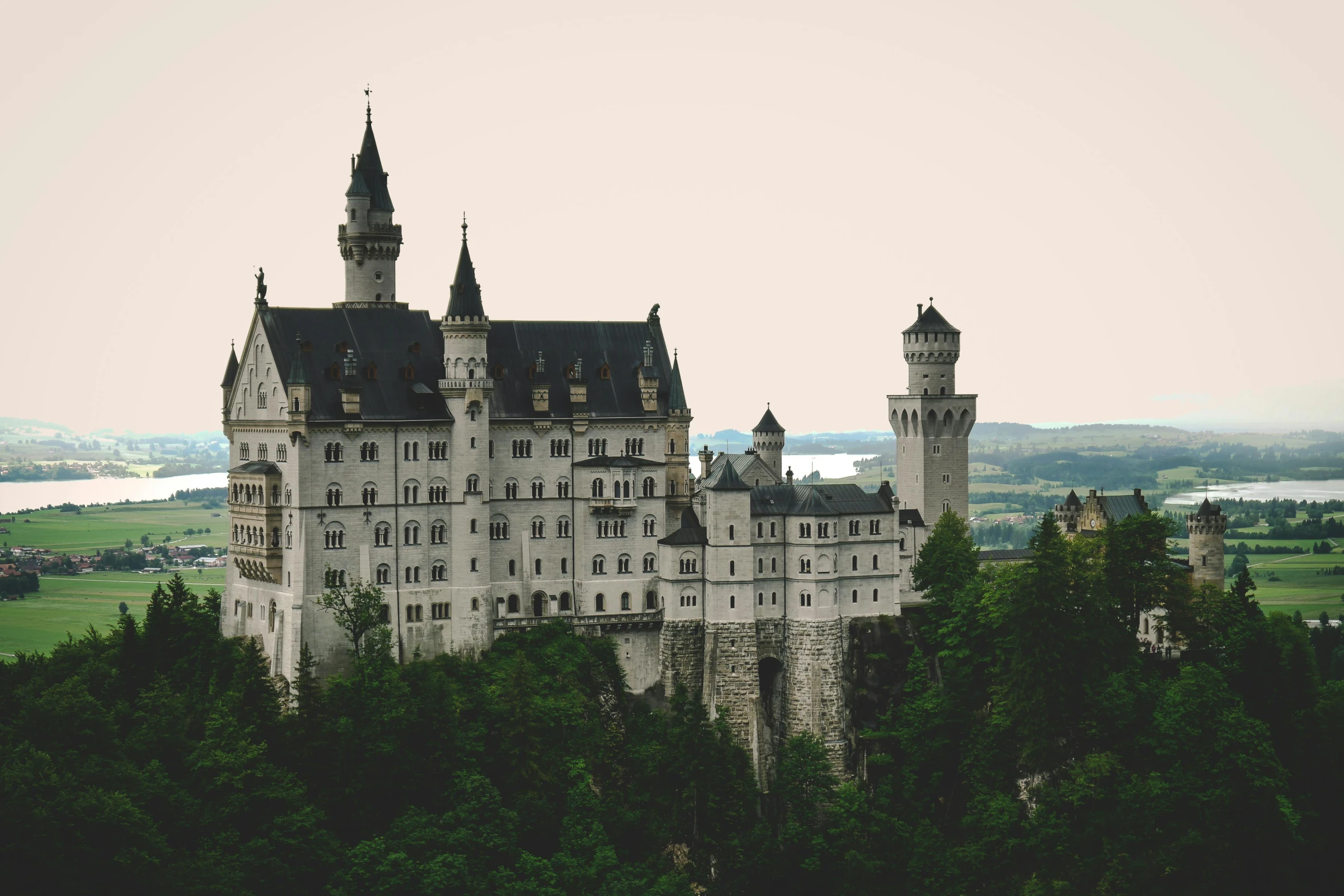 a castle sitting on top of a lush green hillside, pexels contest winner, german romanticism, white, gothic building style, grey, sleeping beauty fairytale