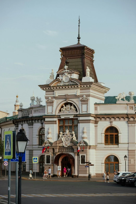 a large white building with a clock tower, inspired by Mihály Munkácsy, art nouveau, entrance, theater, zdzislaw, zoomed in