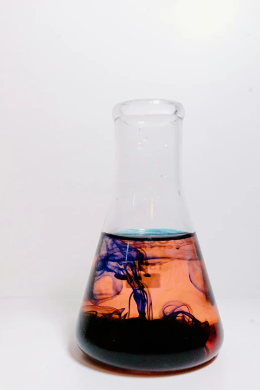 a flask filled with liquid sitting on top of a table, by Doug Ohlson, beakers of colored liquid, back - shot, tar - like, vapor