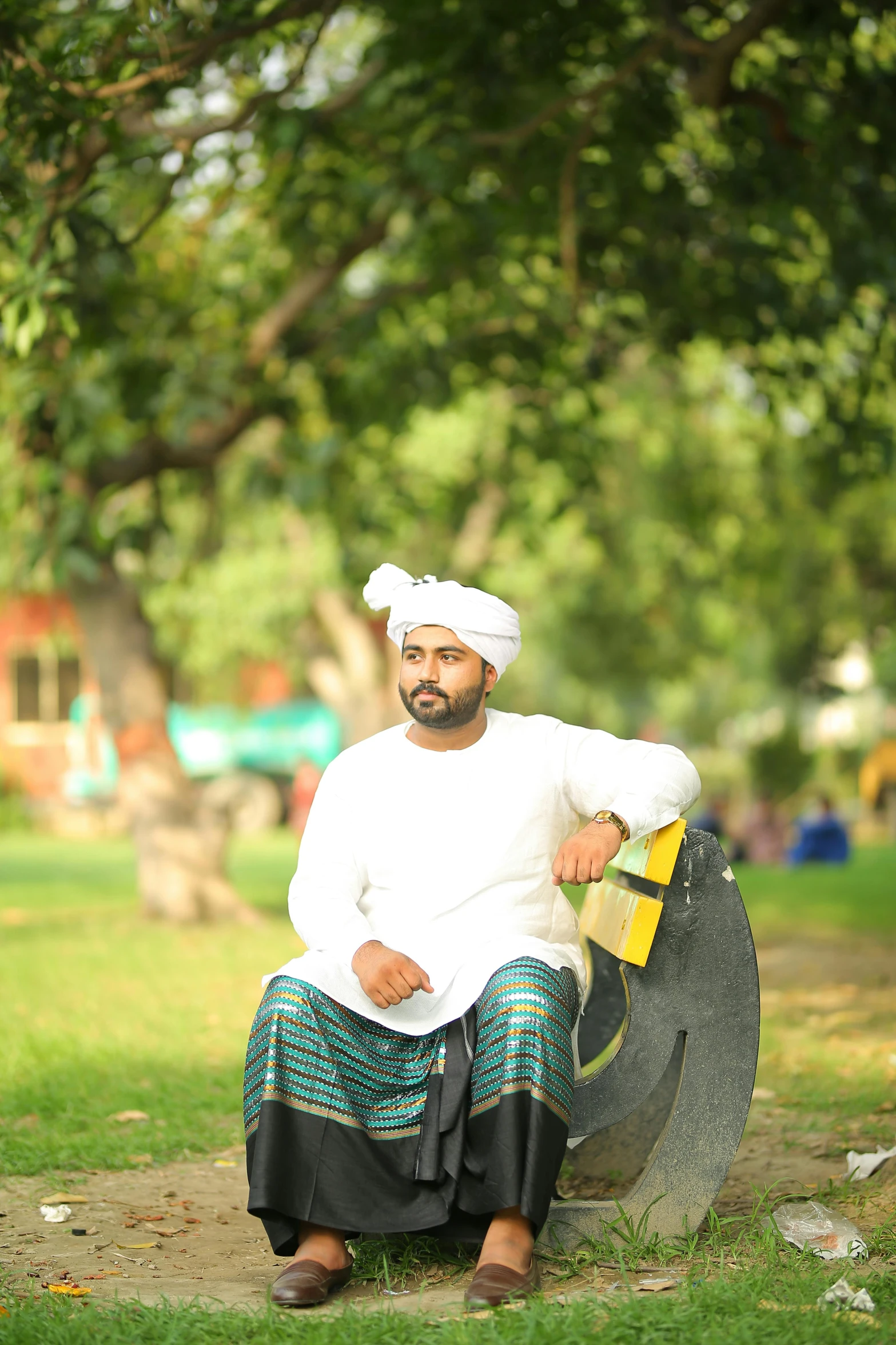 a man sitting on a bench in a park, an album cover, inspired by Sardar Sobha Singh, pexels contest winner, happening, wearing traditional garb, young commoner, sittin, profile image