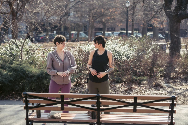 a couple of women standing next to each other on a bench, happening, jc park, 5k, photograph, realistic ”