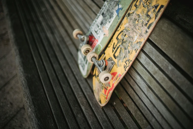 a couple of skateboards sitting on top of a wooden bench, a picture, unsplash, graffiti, close - up photo, homemade, shot on sony a 7, deck