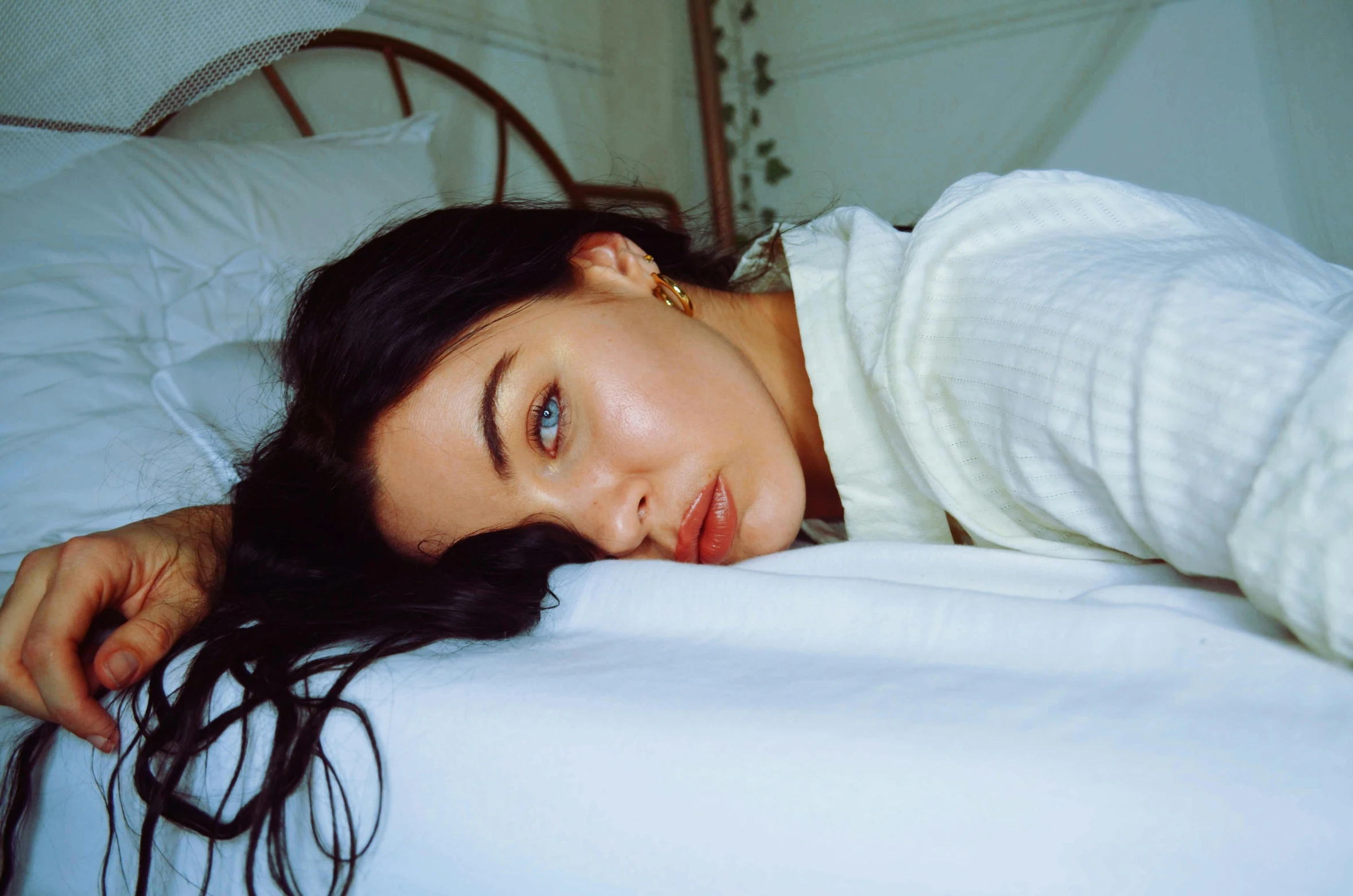 a beautiful young woman laying on top of a bed, inspired by Elsa Bleda, trending on pexels, photorealism, raised eyebrows, wearing a white sweater, megan fox, gif