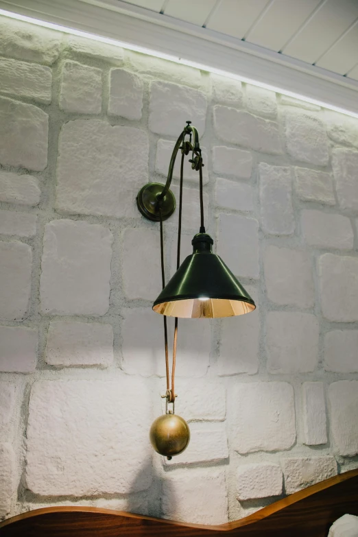 a lamp that is on a wall next to a bed, bells, ilya, monocle, old world