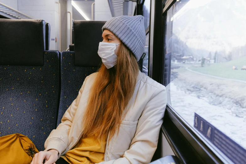 a woman wearing a face mask on a train, by Emma Andijewska, trending on pexels, ski mask, avatar image, pollution, wearing a yellow hoodie