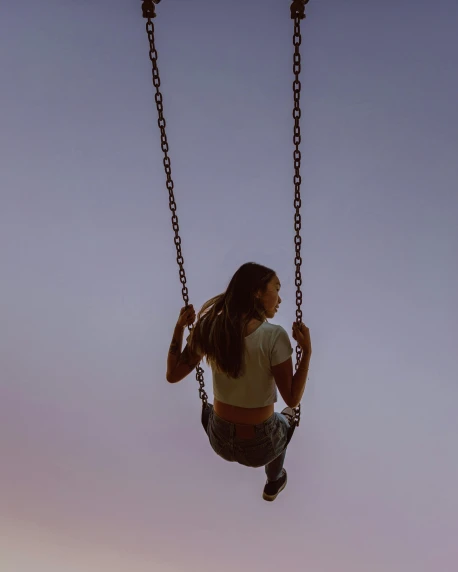 a woman sitting on a swing at sunset, inspired by Elsa Bleda, pexels contest winner, aestheticism, desaturated, people falling off a playground, sitting on top of a rainbow, plain background