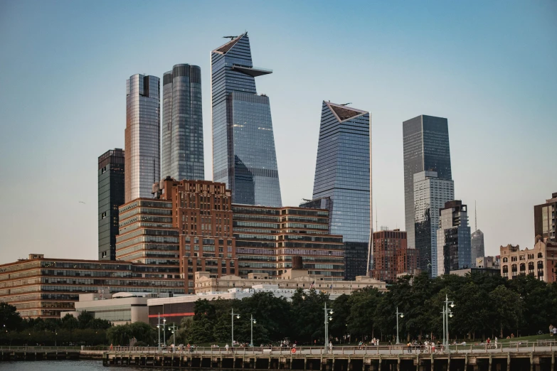 a large body of water with a bunch of tall buildings in the background, a picture, by William Berra, unsplash contest winner, hypermodernism, daniel libeskind, three towers, seen from outside, norman foster