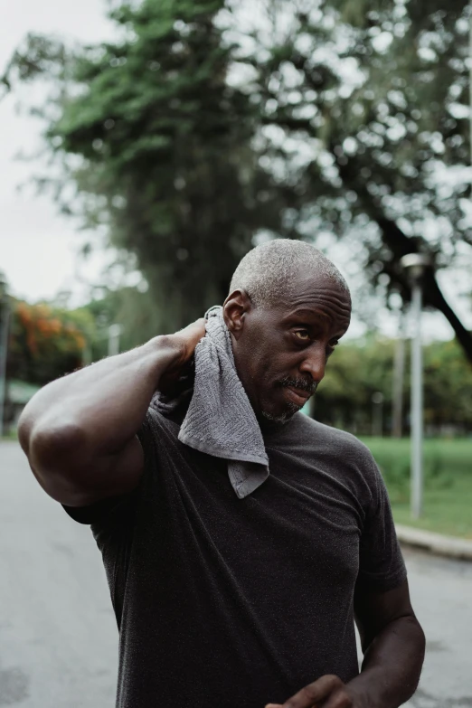 a man with a towel around his neck, by Ceferí Olivé, pexels contest winner, happening, wearing a tee shirt and combats, lance reddick, mike ehrmantraut, gif