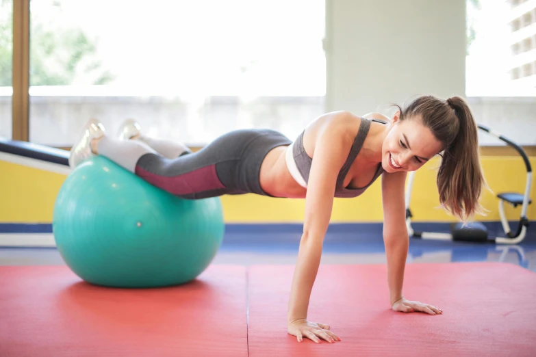 a woman doing push ups on an exercise ball, by Arabella Rankin, pexels contest winner, foreground background, full colour, profile image, thumbnail