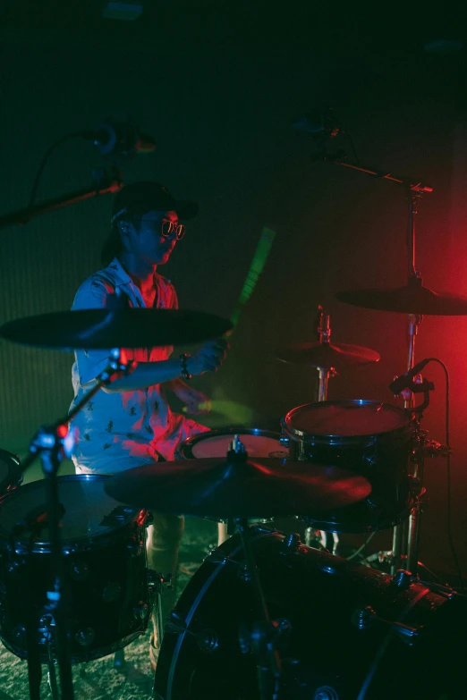 a man that is sitting in front of a drum, an album cover, unsplash, stoner rock concert, low - lighting, gemma chen, drum scanner