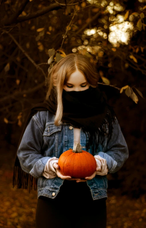 a woman holding a pumpkin in her hands, an album cover, by Adam Marczyński, pexels, face covered, kid, 15081959 21121991 01012000 4k