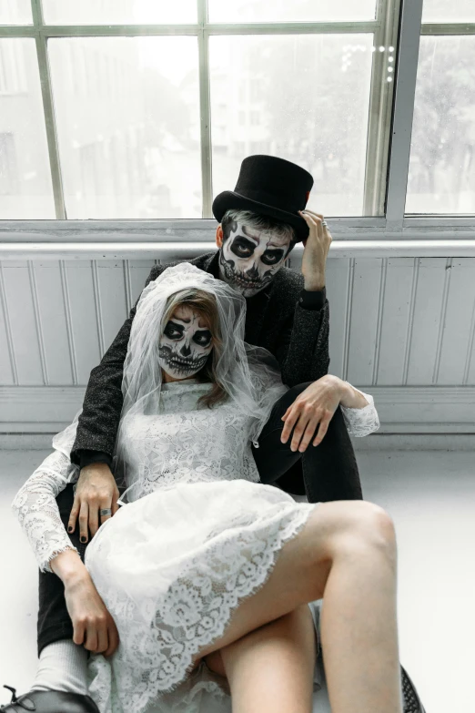 a man in a top hat sitting next to a woman in a wedding dress, pexels contest winner, international gothic, skull face paint, human bodies intertwined, in a white room, zombie's