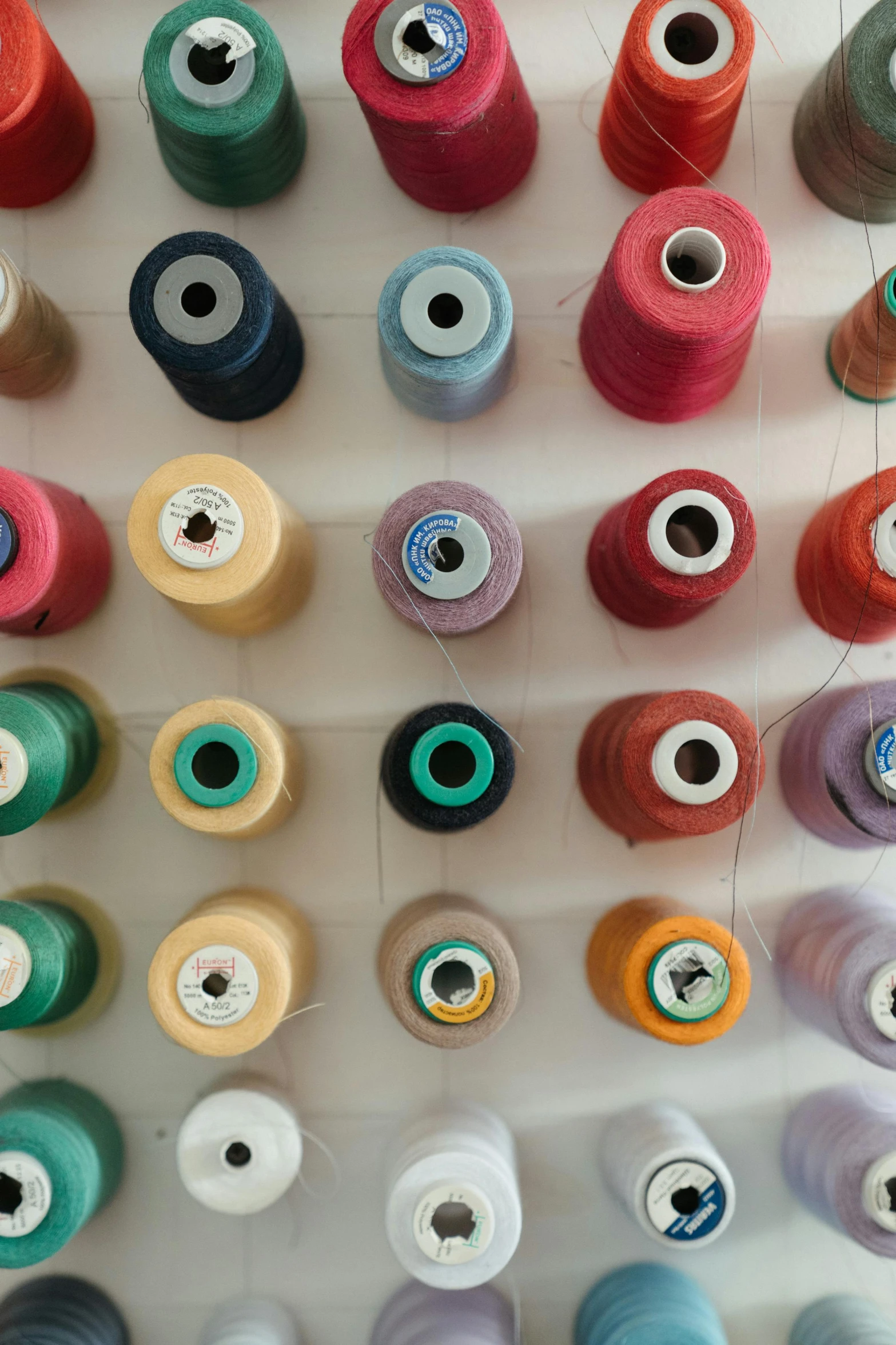 many spools of thread on a white surface, unsplash, large patches of plain colours, 64x64, color image, a tall