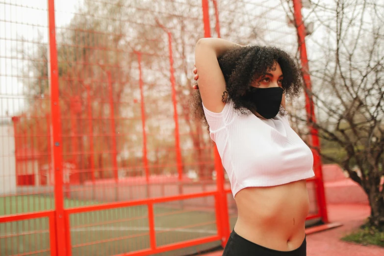 a woman standing on a tennis court wearing a face mask, pexels contest winner, cottagecore!! fitness body, black young woman, bralette, with a covered face