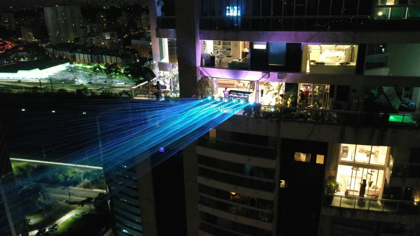 an aerial view of a city at night, a hologram, by Alejandro Obregón, laser beam ; outdoor, penthouse, 3 meters, fiberoptic hair