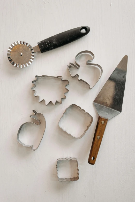 a bunch of cookie cutters sitting on top of a table, a still life, inspired by Jan Müller, unsplash, folk art, hedgehog, metal kitchen utensils, high angle close up shot, on clear background