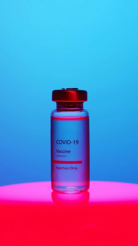 a bottle of liquid sitting on top of a table, a picture, by Jeanna bauck, shutterstock, medical stitches vaporwave, blue and red two - tone, covid, 8 0. lv