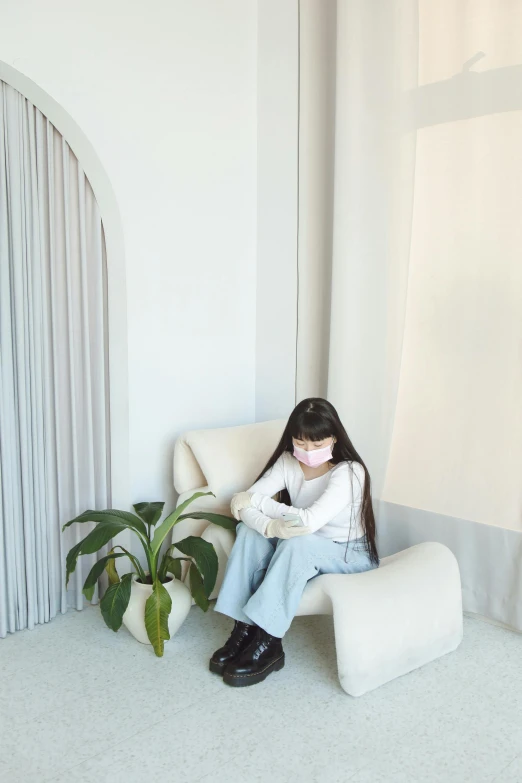 a little girl sitting on a chair in a room, an album cover, by helen huang, trending on pexels, white soft leather model, reading nook, wearing facemask, simple aesthetic