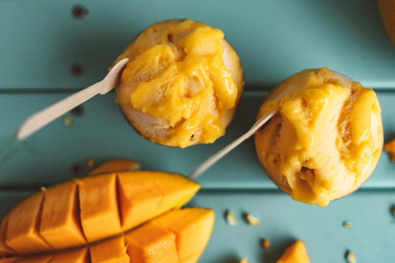 a couple of muffins sitting on top of a table, trending on unsplash, mango, eating ice cream, vibrantly lush, alternate angle