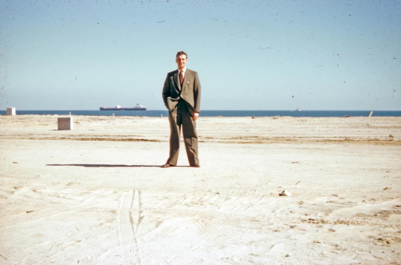 a man standing on top of a sandy beach, an album cover, by Bertram Brooker, gulf, museum archive photo, richard nixon, ground breaking