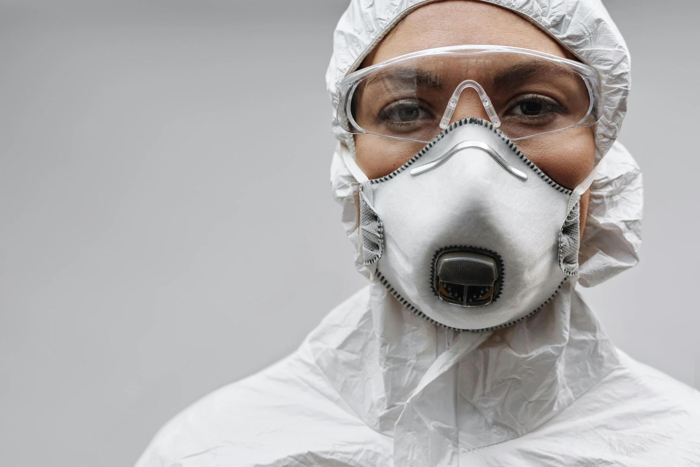 a person wearing a protective suit and goggles, pexels contest winner, hyperrealism, white, fan favorite, sterile background, avatar image