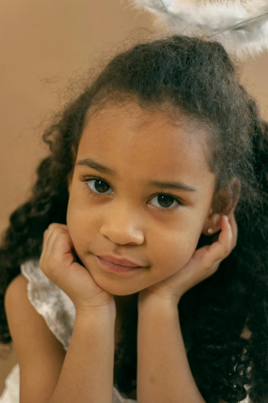 a little girl with an angel wings on her head, an album cover, pexels, mannerism, mixed race, thoughtful ), 🤤 girl portrait, sitting down