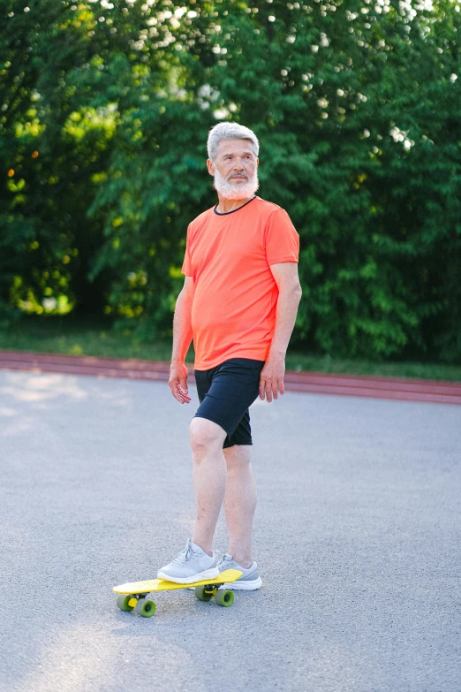 a man standing on a skateboard in a parking lot, wearing an orange t shirt, an oldman, wearing fitness gear, profile image