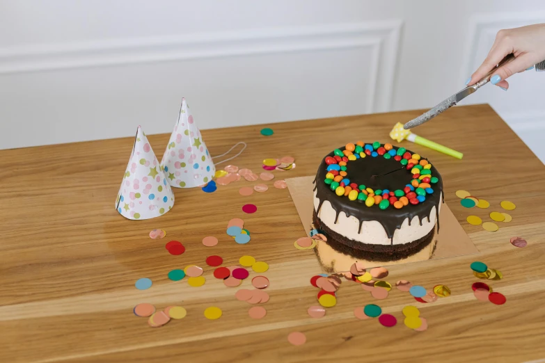 a person cutting a birthday cake with a knife, inspired by Damien Hirst, unsplash, high resolution product photo, 360 degree view, wooden art toys on base, confetti