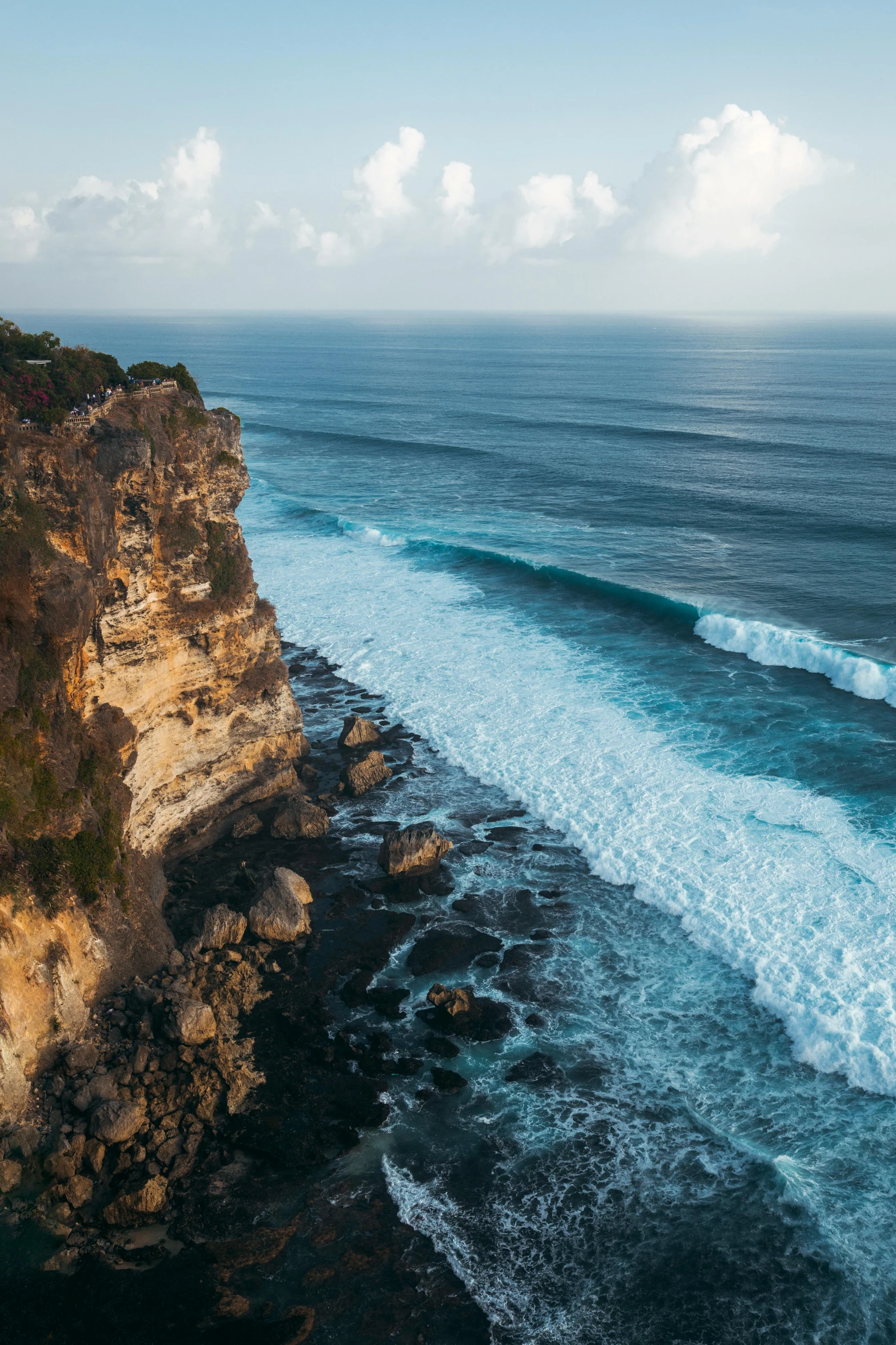 a large body of water next to a cliff, pexels contest winner, bali, pristine rippling oceanic waves, slide show, surfing