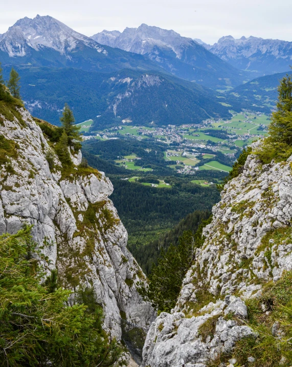 a view of a valley from the top of a mountain, by Karl Gerstner, pexels contest winner, happening, limestone, two mountains in background, lush surroundings, high-resolution photo