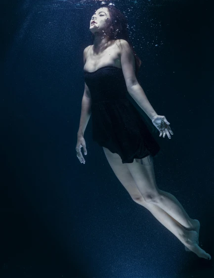 a woman in a black dress swimming under water, promo image, dark blues, shot with sony alpha, deep sadness
