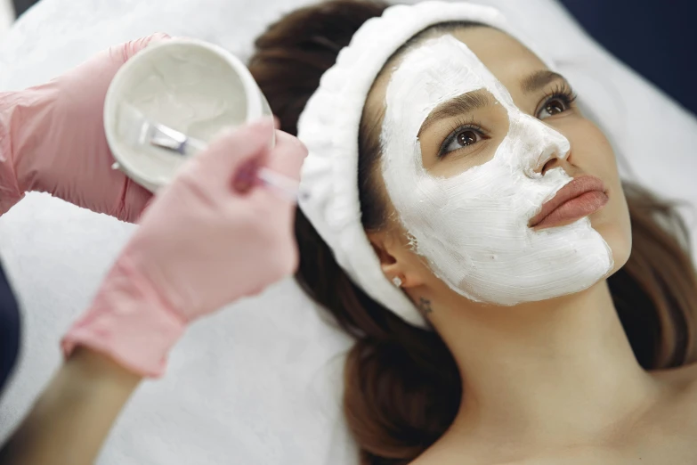 a woman getting a facial mask at a beauty salon, by Julian Allen, fan favorite, thumbnail, femalev beauty, white cheeks