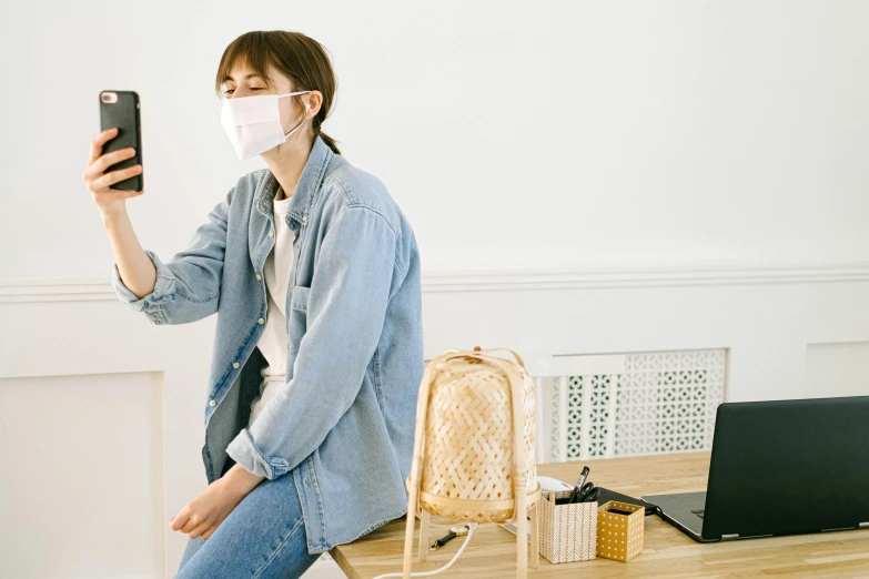 a woman wearing a face mask taking a selfie, trending on pexels, seated on wooden chair, first aid kit, japanese collection product, standing on a desk