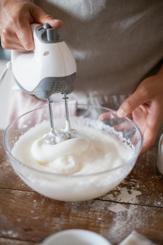 a person mixing something in a bowl on a table, frosted, fan favorite, foam, vibrating