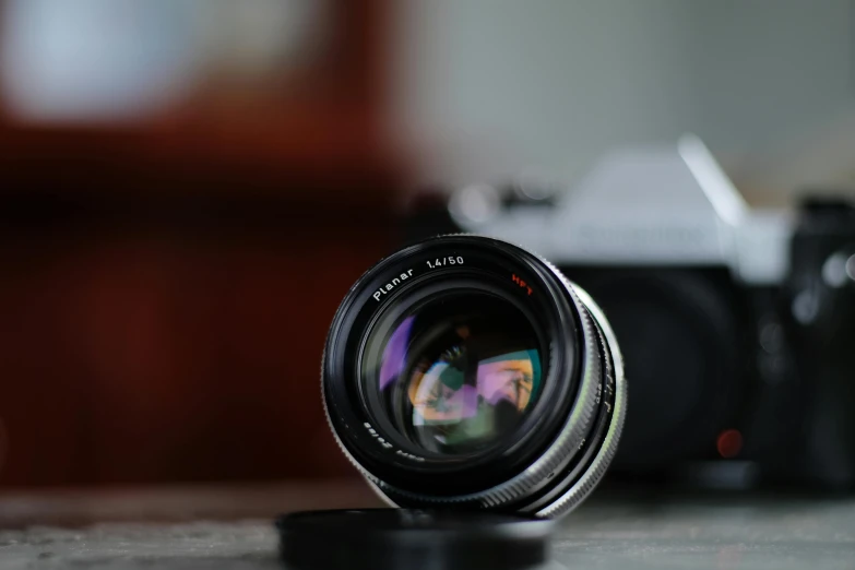 a close up of a camera lens on a table, a picture, unsplash, photorealism, zeiss 50mm f1.8, medium format. soft light, fujifilm”, a photo of an old opened camera