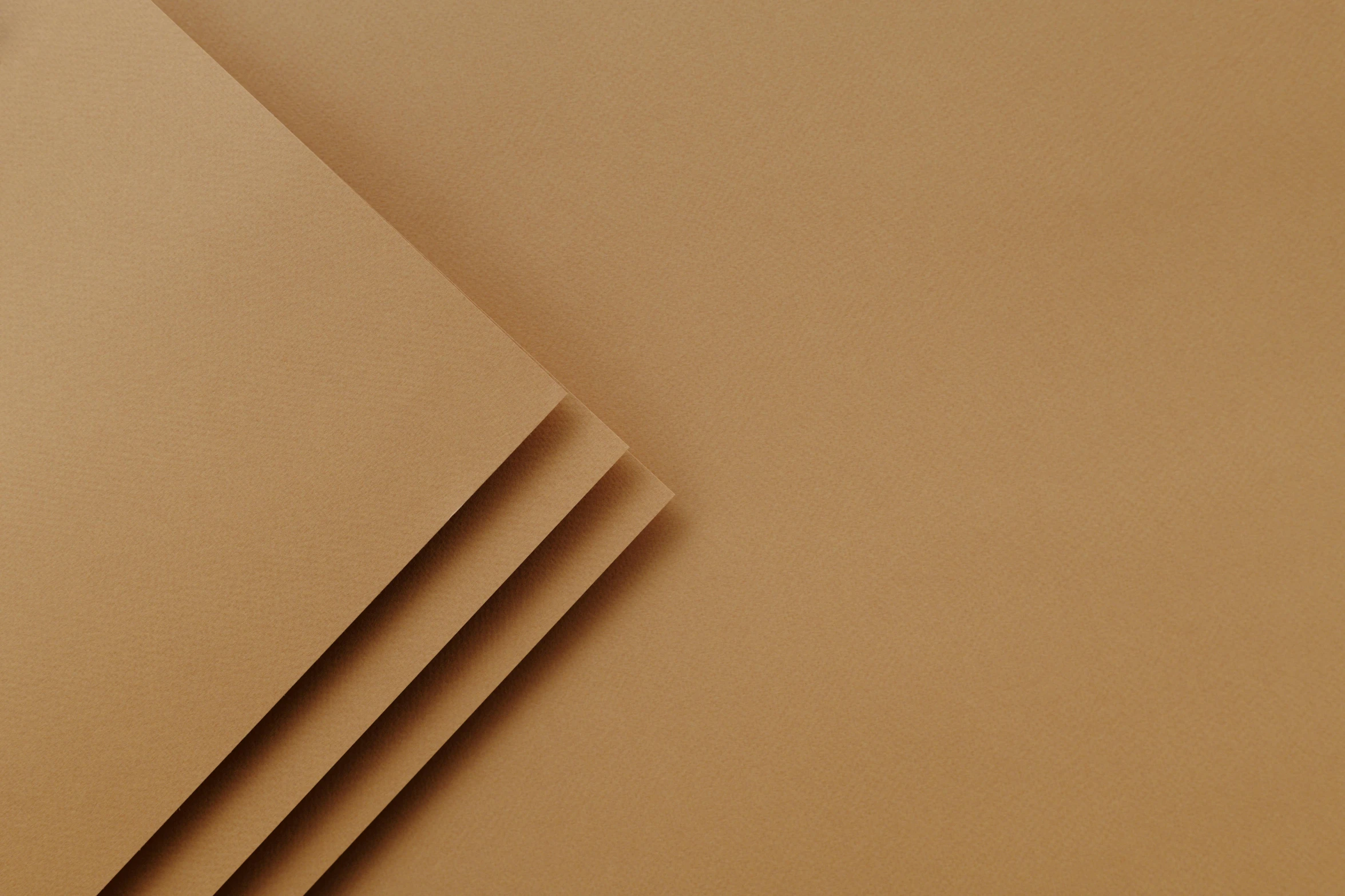 three sheets of brown paper stacked on top of each other, an ultrafine detailed painting, bauhaus, detailed product image, high angle close up shot, solid colour background”, bronze poli