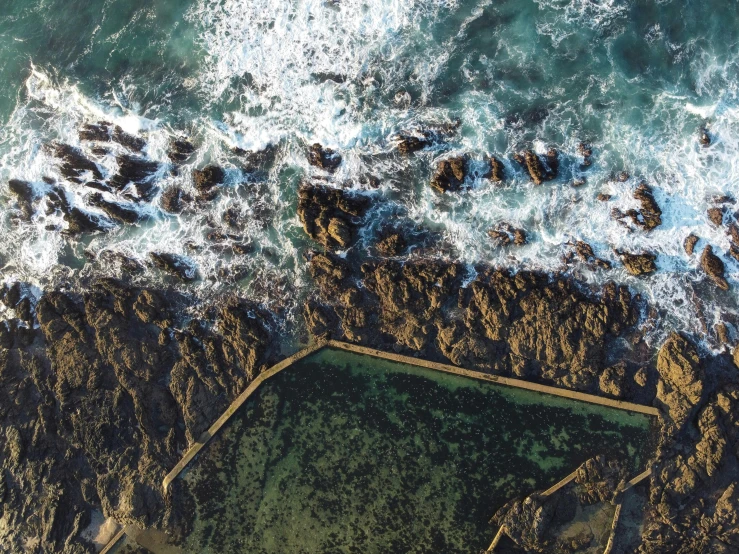 a large body of water next to a rocky shore, pexels contest winner, birds eye overhead perspective, pools of water, thumbnail, san francisco