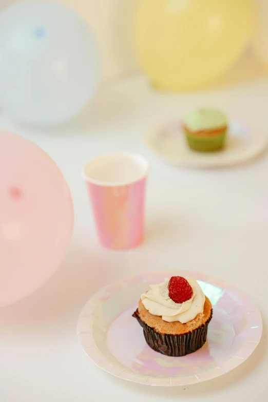 a cupcake sitting on top of a white plate, balloon, iridescent and opalescent, paper cup, arper's bazaar
