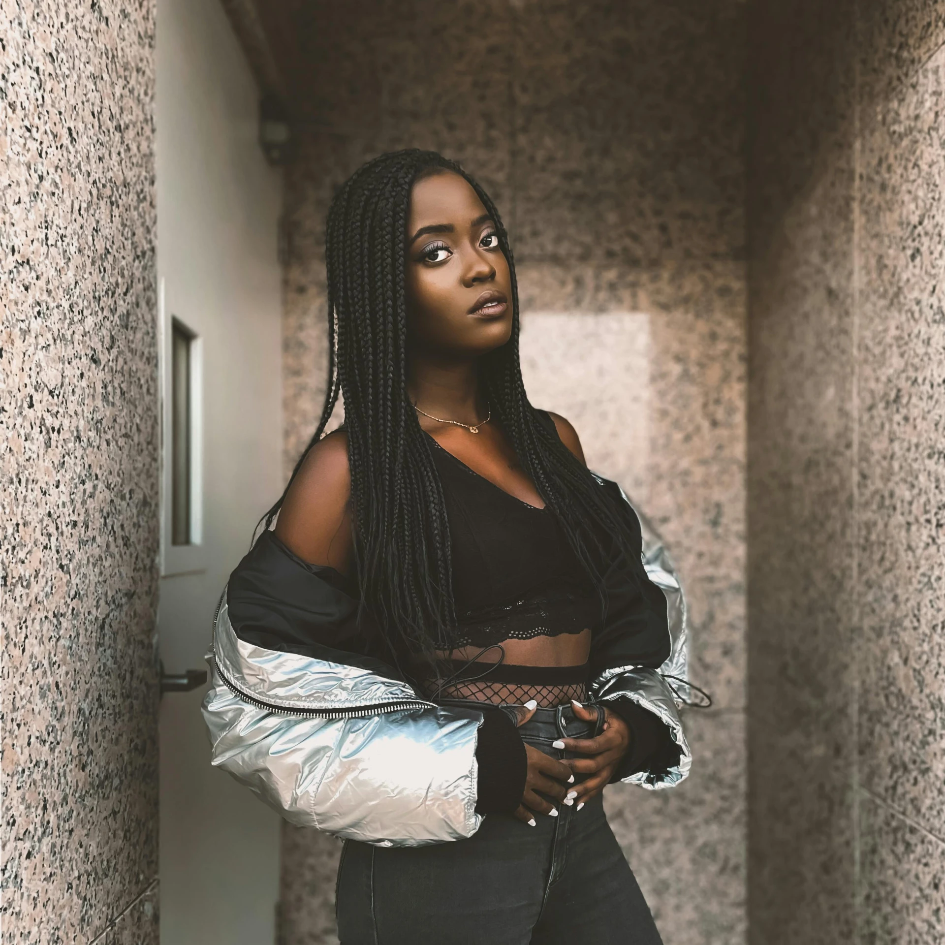 a woman standing in a hallway next to a wall, an album cover, pexels contest winner, black teenage girl, badass pose, wearing crop top, taken with sony alpha 9